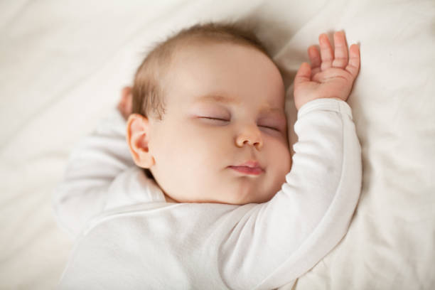 bebé recién nacido durmiendo sobre fondo blanco. niño pequeño para dormir, acostarse (bebé hasta un mes) - sleep fotografías e imágenes de stock