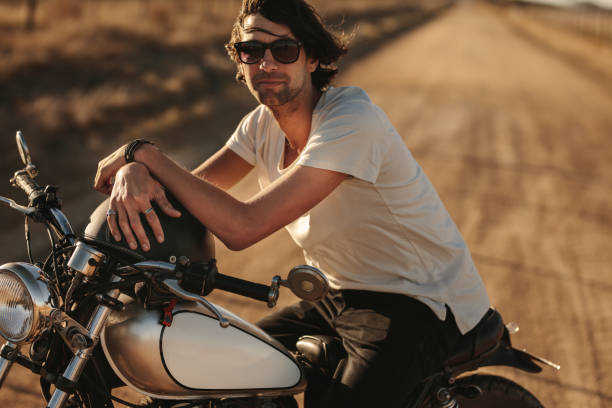 istock Man sitting on a vintage motorcycle outdoors 1005948278