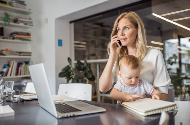 istock Single mother with baby working in office 1005949456