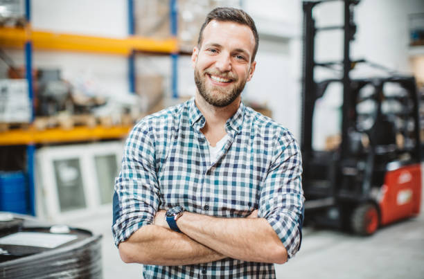 Working in warehouse Distribution worker working in warehouse. He checking merchandise and collecting information about stock man beard plaid shirt stock pictures, royalty-free photos & images