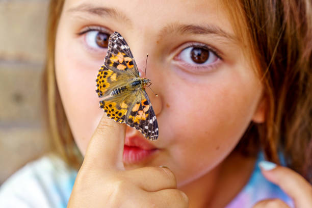 istock Ten year old girl with butterfly on her finger 1005955818