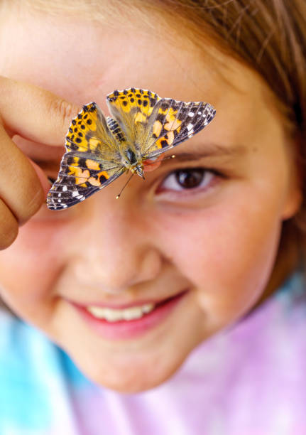 istock Ten year old girl with butterfly on her finger 1005955856