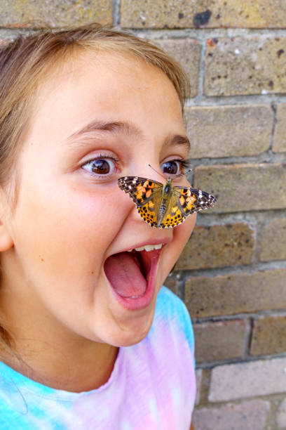 istock Ten year old girl with butterfly on her nose 1005955874