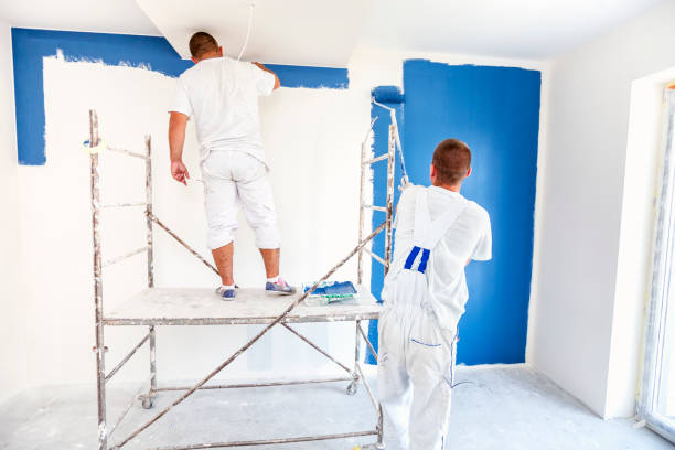 istock House painters beginning to paint a large blue wall 1005956588