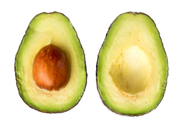 istock Isolated avocado fruit. Two slices of avocado with core  isolated on the white background. 1005956598