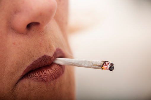 Woman smokes a marijuana joint