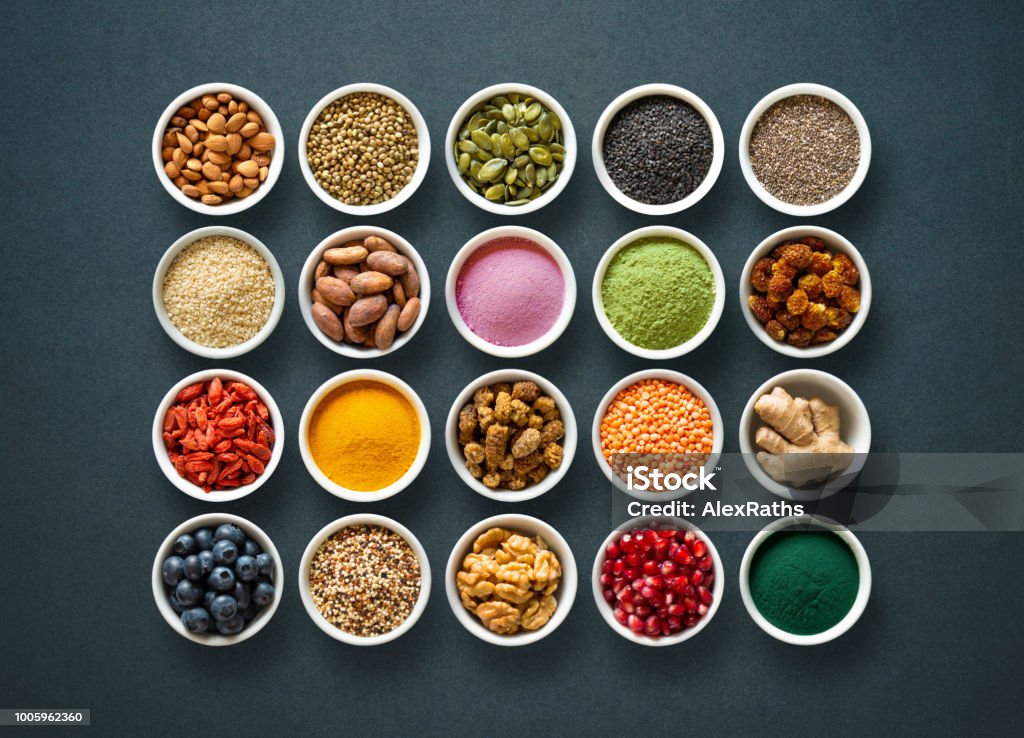 Various colorful superfoods in bowls on dark background Various colorful superfoods as acai powder, turmeric, matcha green tea, spirulina, quinoa, pumpkin seeds, blueberry, dried goji berries, cape gooseberries, raw cocoa, hemp seeds and other in bowls on dark background Ingredient Stock Photo