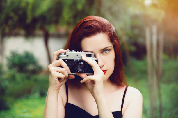 istock Young woman with retro camera 1005967212