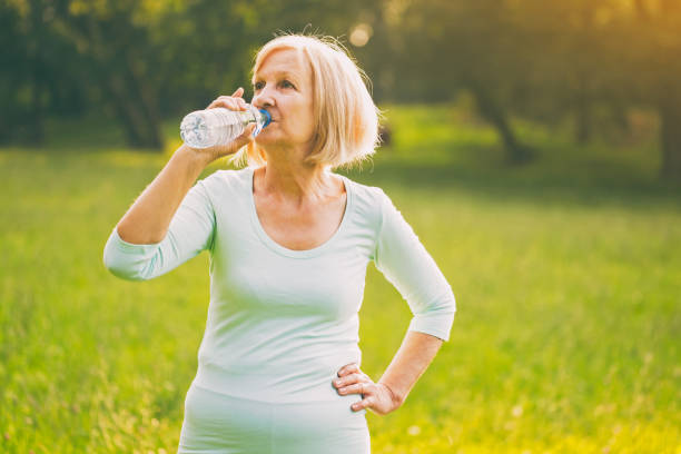 istock Sporty senior woman drinking water 1005968236