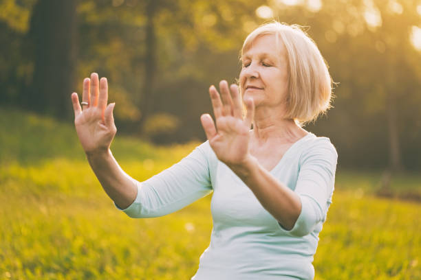 Senior woman exercise Tai Chi Senior woman enjoys  exercise Tai Chi in the nature.Image is intentionally toned. martial arts photos stock pictures, royalty-free photos & images