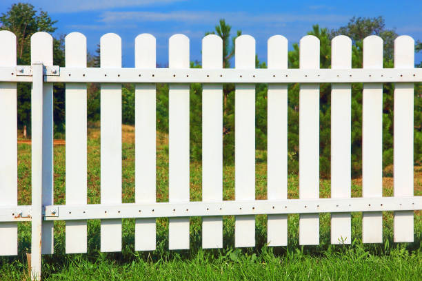 istock White wooden fence on green grass. 1005983808