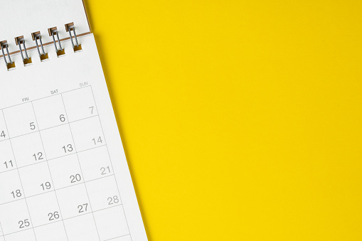 Calendario limpio blanco sobre fondo amarillo sólido con espacio de copia, negocios, viajes o concepto de planificación de proyectos photo