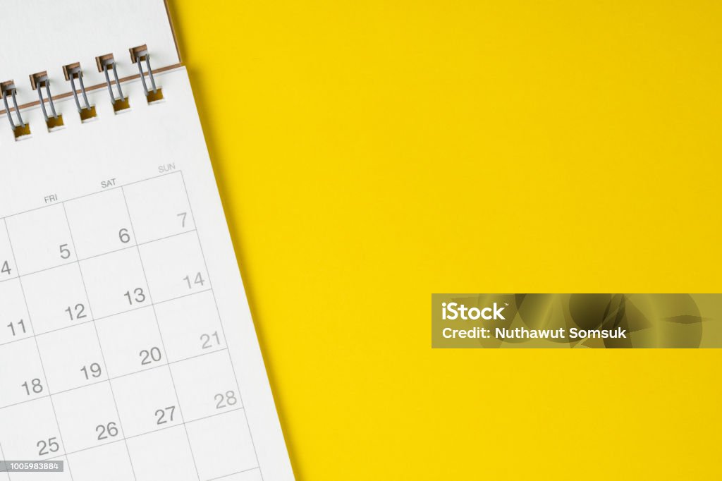 White clean calendar on solid yellow background with copy space, business, travel or project planning concept White clean calendar on solid yellow background with copy space, business meeting schedule, travel planning or project milestone and reminder concept. Calendar Stock Photo