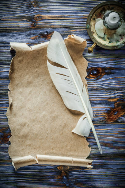 istock Vintage paper roll feather candlestick on blue wooden background 1005984078