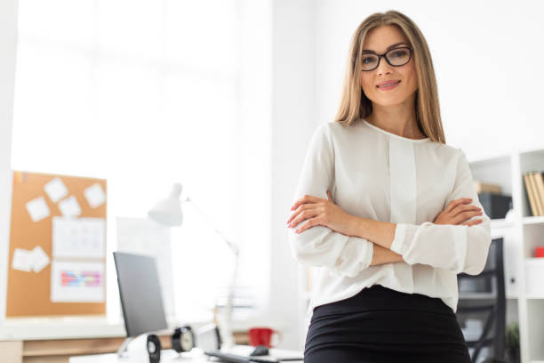 istock A young girl is standing leaning on a table in the office. 1005988664