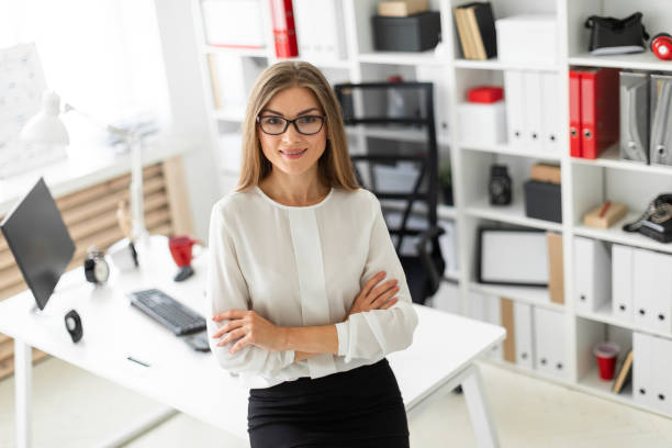 istock A young girl is standing leaning on a table in the office. 1005988686
