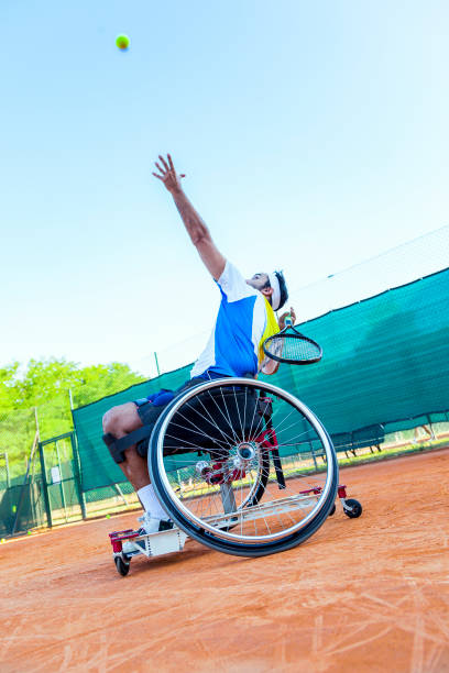 disabled tennis player hits the ball for service stock photo