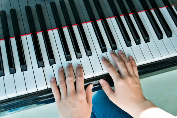 istock Woman hands playing piano 1005998248
