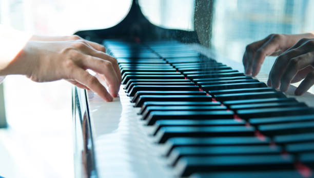istock Woman hand playing piano 1005998626