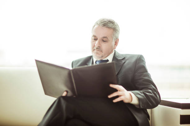 istock successful businessman studies working papers sitting on the sofa in the private office 1005999390