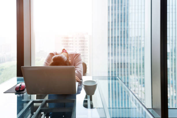 istock Tired woman sleeping on desk 1005999460