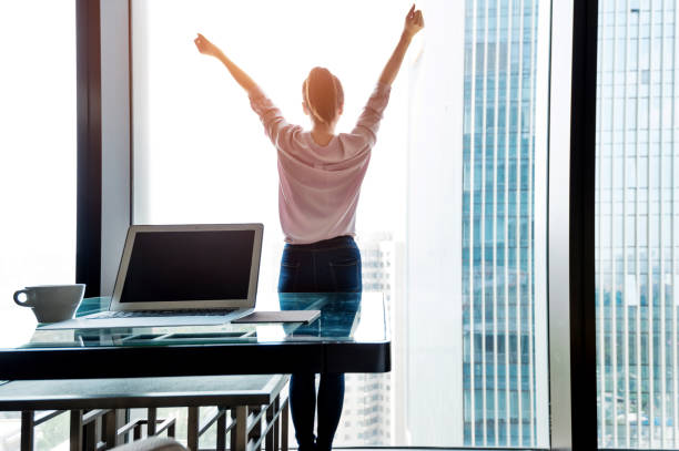 istock Woman standing and looking out the window 1006001654