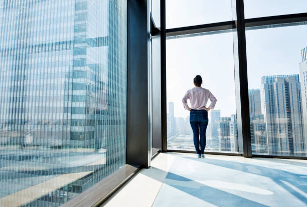 istock Woman standing and looking at cityscape 1006001878