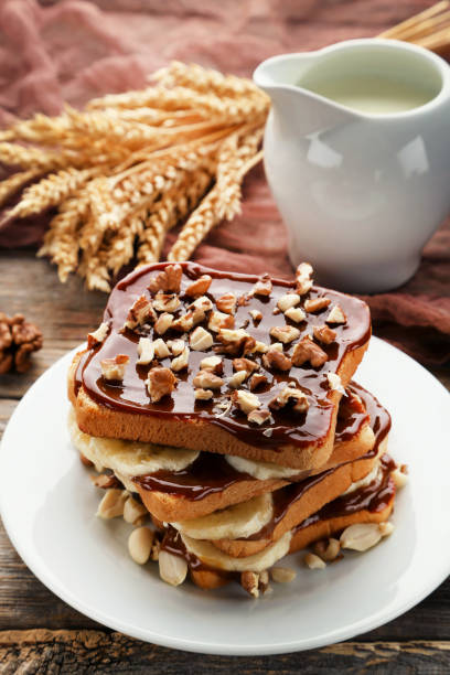istock Toasts bread with bananas, walnuts and chocolate on grey wooden table 1006003298