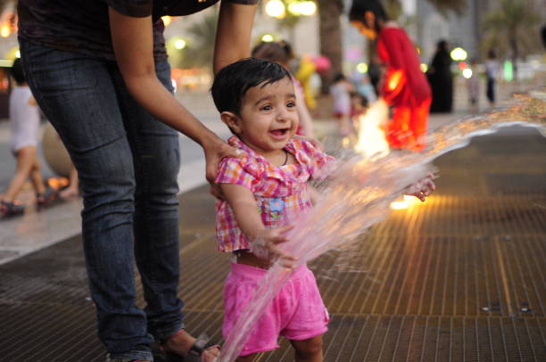 Smiling girl laughing while splashing water in the fountain.