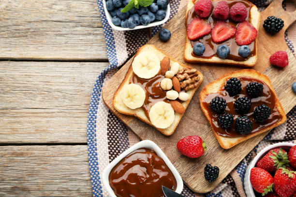 istock Toasts bread with berries on brown cutting board 1006005956
