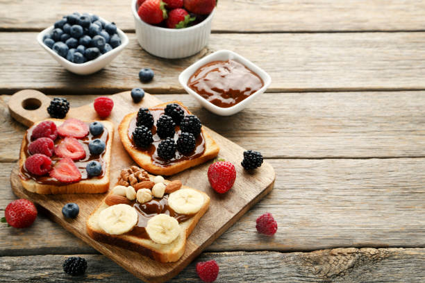istock Toasts bread with berries on brown cutting board 1006006500