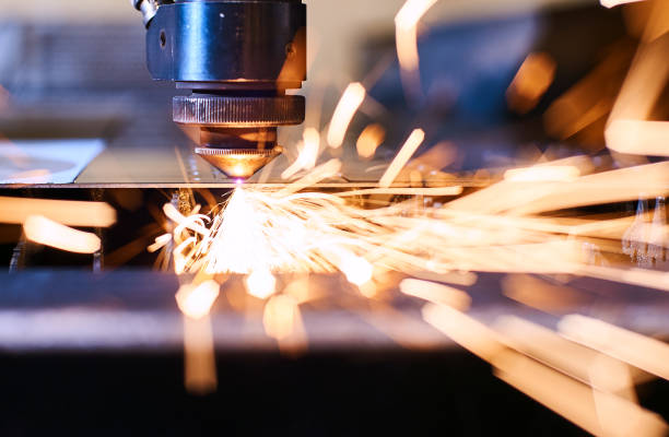 CNC Laser cutting of metal, modern industrial technology. Small depth of field. CNC Laser cutting of metal with sparks, modern industrial technology. Small depth of field. laser cutting metal stock pictures, royalty-free photos & images
