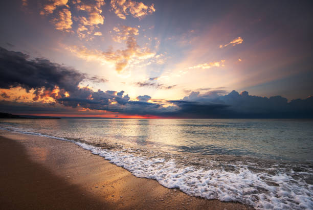 istock Colorful ocean beach sunrise with deep blue sky and sun rays. 1006017914