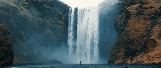 frau mit blick auf wasserfall am skogafoss, island. - mountain majestic park cliff stock-fotos und bilder