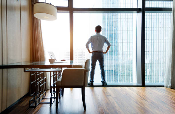 istock Businessman standing and looking out the window 1006022614