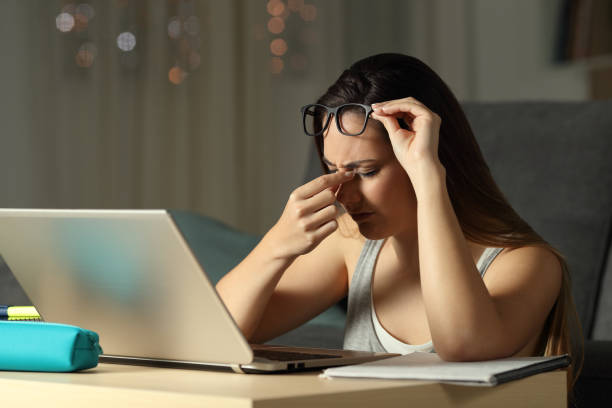 istock Exhausted student suffering eyestrain in the night 1006022776