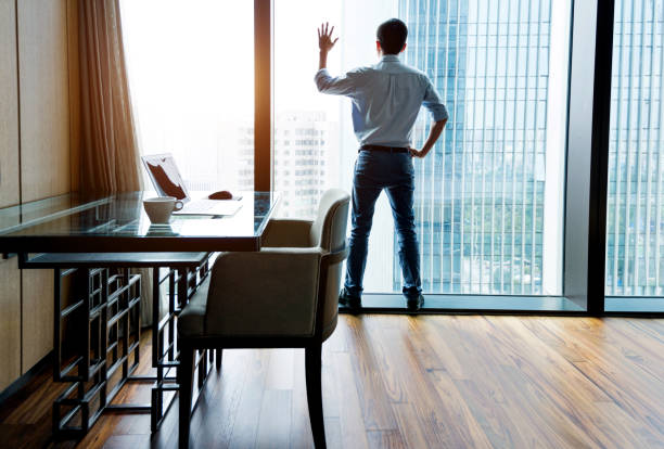 istock Businessman standing and looking out the window 1006022830
