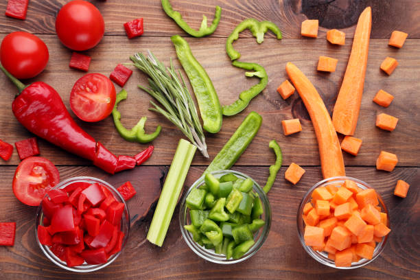 istock Fresh sliced vegetables in bowls on brown wooden table 1006042430