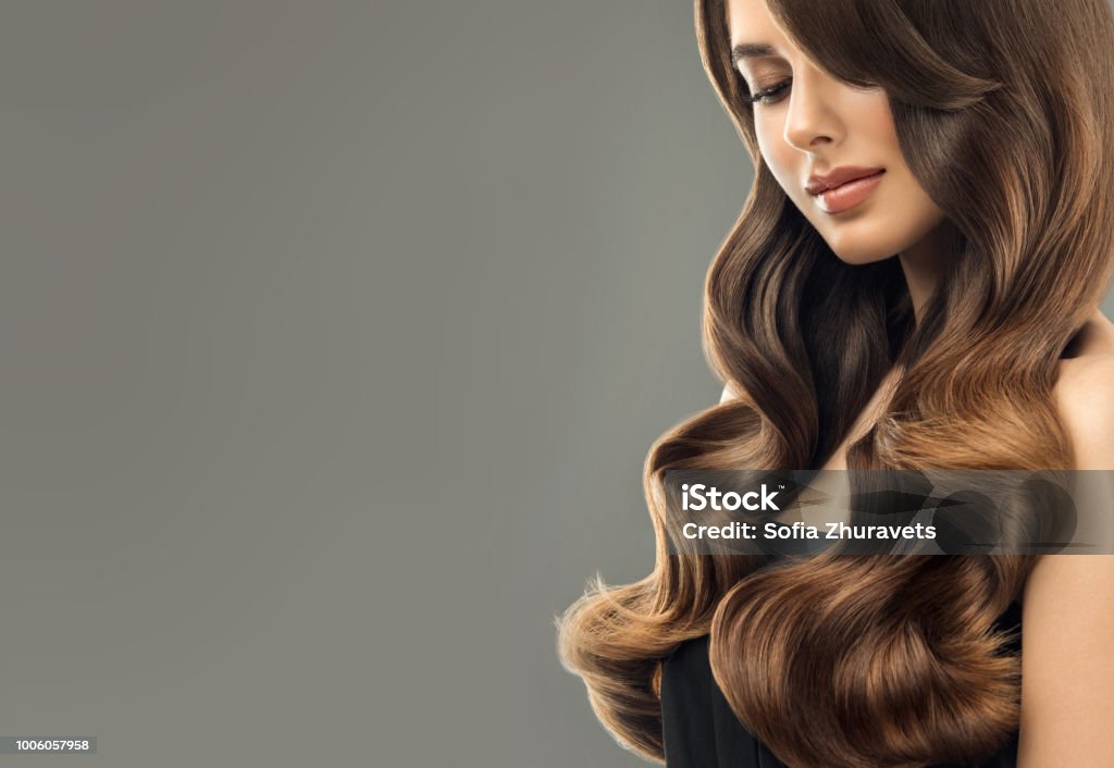 Junge, braunen Haaren schöne Modell mit langen, lockigen, gepflegtes Haar. Ausgezeichnete Haare Wellen. Friseur-Kunst und Haare Pflege. - Lizenzfrei Model Stock-Foto