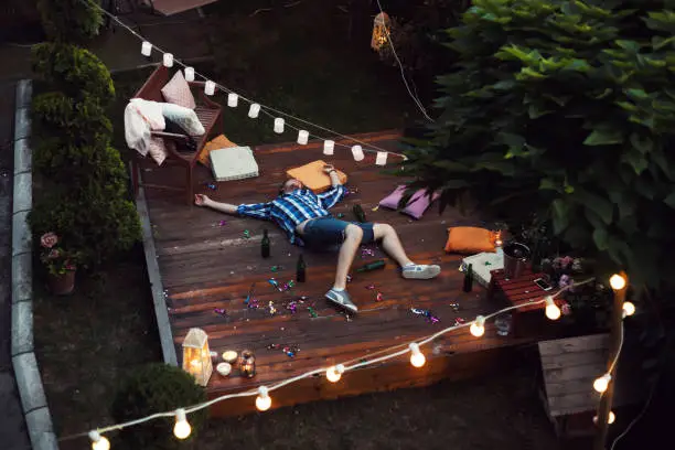 Young man sleeping after party in a backyard