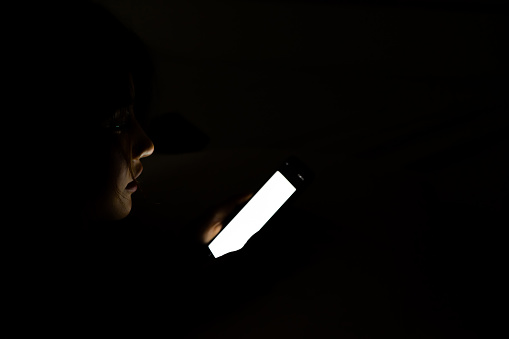 woman face using smart phone on bed at night.
Beautiful Asian girl at night in a dark room with mobile phone.
Young beautiful lady using cell phone - technology, social network, insomnia concept