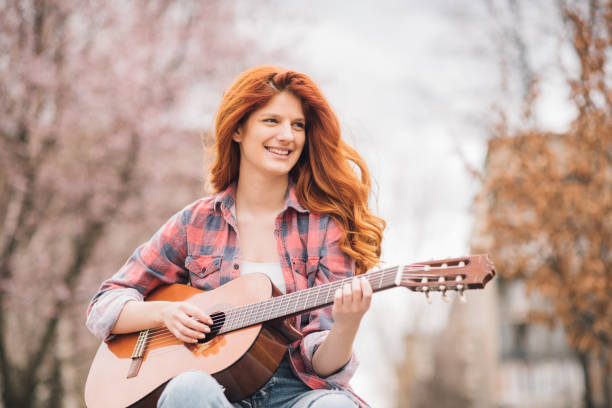 sonriendo la guitarra de galjanoplastia de chica pelirroja - lumberjack shirt fotografías e imágenes de stock