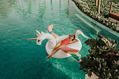 Carefree woman on inflatable unicorn