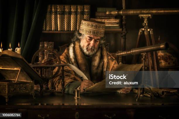 Astronomer Writing On Parchment With Feather Pen Stock Photo - Download Image Now - Ancient, Medieval, Old