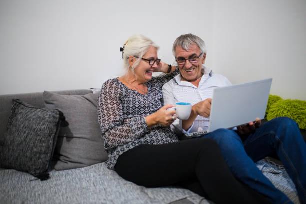 istock Senior couple web surfing on internet with laptop 1006082790