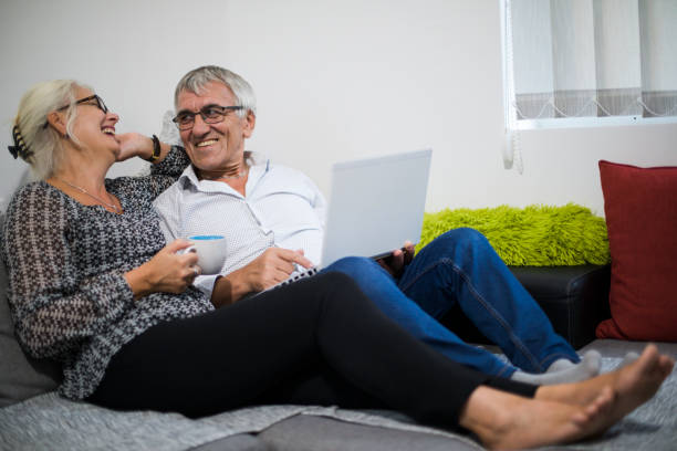 istock Senior couple web surfing on internet with laptop 1006085472