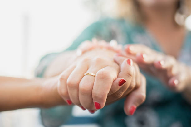 istock Two female human hands holding each other 1006088484