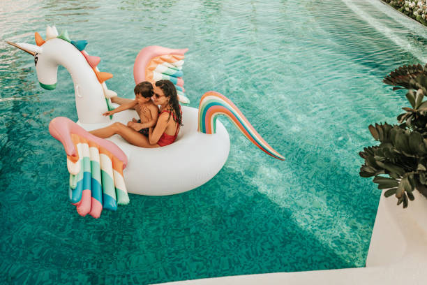 mother with son on inflatable unicorn - offspring child lying on back parent imagens e fotografias de stock