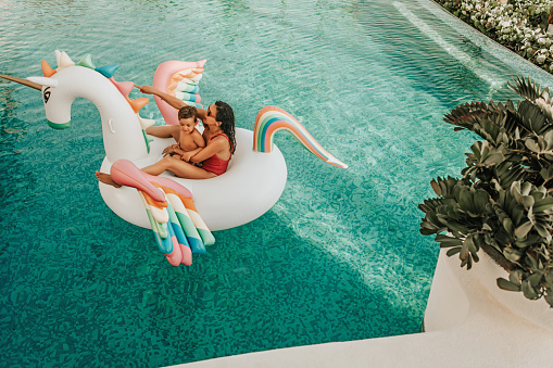 Mother with son on inflatable unicorn
