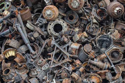 Old and rusty automotive parts are stacked together. Old and rusty iron scrap.
